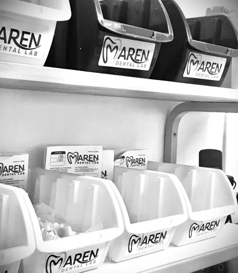 Labelled Maren Dental Lab work boxes on the lab shelves